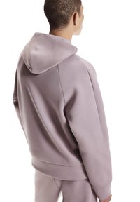 Hele lilla kapuutsiga dressipluus lõdva lõikega, mis on varustatud suure kapuutsiga, siledapinnalise tekstuuriga, küljesauma detailiga ning logoga serva lähedal.