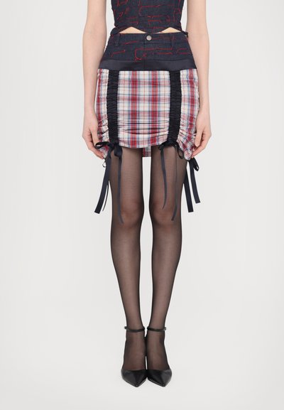 Plaid skirt with ruched sides, navy accents and ribbon ties, paired with sheer black tights and pointed toe black heels.