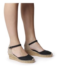 Černé plátěné espadrilky s pleteným juty klínem a kotníkovými pásky, s zaoblenou špičkou a texturovaným svrchním designem.