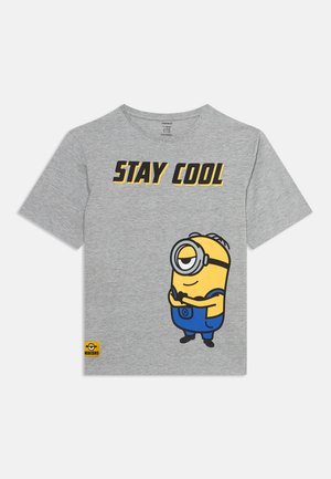 T-shirt gris avec le texte "STAY COOL" et un personnage Minion debout les bras croisés portant une salopette bleue.