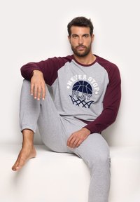 Sweatshirt gris avec manches raglan bordeaux, arborant un graphique de basket-ball et du texte, associé à un pantalon de jogging gris, le tout en tissu doux.