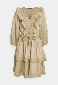 Robe beige avec décolleté volanté, tissu texturé, manches longues, taille cintrée et jupe à volants avec des accents en dentelle.
