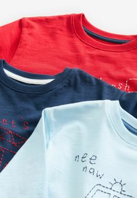 Trois sweatshirts à col rond en rouge, bleu marine et bleu clair, ornés de textes et motifs brodés, fabriqués en coton doux.