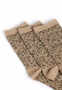 Drie paren beige sokken met een metallic glans. Elk paar heeft een zwart luipaardprintpatroon. Zachte textuur en geribbelde boorden.