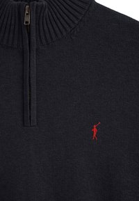 Dunkelblauer Viertelreißverschluss-Pullover mit geripptem Kragen. Ein kleines rotes gesticktes Logo eines Golfspielers befindet sich auf der linken Brust.