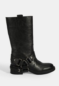 Zwarte leren kniehoge laars met een gestructureerde afwerking, voorzien van dubbele gespen en een chunky hak. Bandjes en metalen accenten voegen bijzondere details toe.