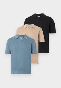 Τρία κοντομάνικα πόλο μπλουζάκια στοιβαγμένα, σε μπλε, μπεζ και μαύρο χρώμα, εμφανίζονται σε απλό λευκό φόντο.