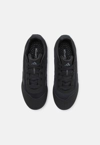 Black athletic shoes with mesh upper, textured rubber toe, and padded collar. Features traditional lacing and a branded insole.