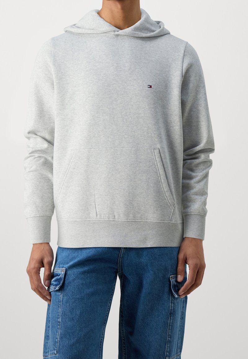 Gray hoodie made of soft fabric, featuring a front pocket, ribbed cuffs, and an adjustable drawstring hood. Small logo accent on the chest.