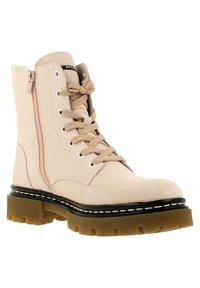 Botín de tobillo de gamuza beige con cordones y cremallera lateral, suela de goma marrón gruesa y ribete negro con costuras blancas.