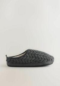 Šedá nazouvací bota vyrobená z texturované látky s prošívaným vzorem, měkkým vnitřním podšívkovým materiálem a plochou černou podrážkou. Otočný poutko na patě pro usnadnění nasazení.