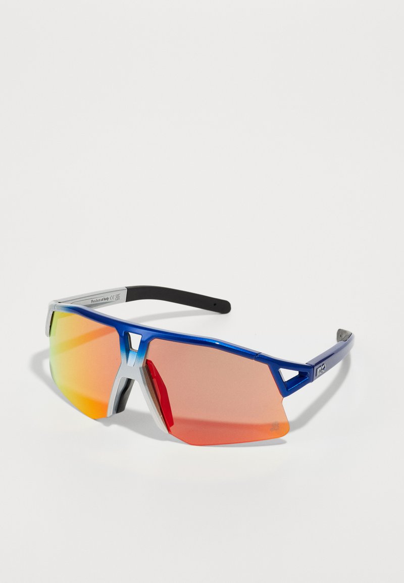 Αθλητικά γυαλιά ηλίου με μπλε μεταλλικό σκελετό, ανακλαστικούς πορτοκαλί και κόκκινους φακούς και μαύρα τμήματα ναού. Γωνιακό σχέδιο με μοναδικές κοπές.