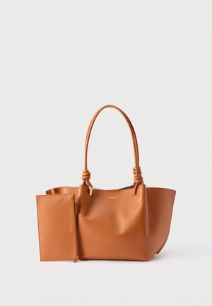 Καφέ δερμάτινη τσάντα χειρός με κόμπους στις λαβές και ταιριαστή αφαιρούμενη θήκη, πάνω σε απλό ανοιχτό φόντο.