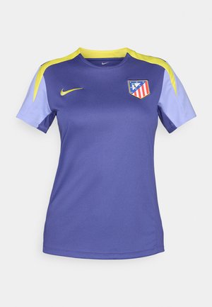 Lilla Nike fotbalsskjorte med gule detaljer og lyse lilla ermer, med Atlético Madrid-logo på venstre bryst.