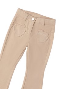 Pantalons en velours côtelé beige avec des poches avant en forme de cœur, des passants de ceinture et une fermeture à bouton, présentés sur un fond blanc.