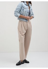 Light blue cropped denim jacket over a grey top, paired with beige pleated trousers and black loafers. Simple design, smooth textures.