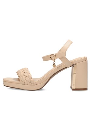 Beige high-heeled sandal with a woven strap, adjustable ankle strap, and a chunky gold-accented block heel. Smooth material and platform design.
