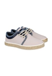 Zapatos de lona color beige claro con acentos en azul oscuro y cordones color crema, que cuentan con una suela de cuerda de yute y una textura suave.