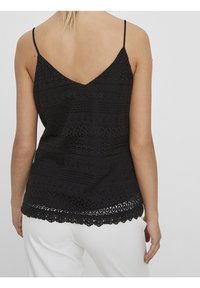 Černý krajkový top s V-zadním výstřihem, který má strukturovaný vzor a vroubkovaný lem. Tenké ramínka a lehký materiál.