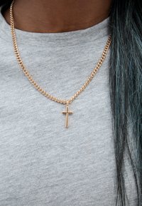 Arany lánc nyaklánc, rajta egy kis, függőleges kereszt medállal, világosszürke ing felett viselve. A lánc lapos, összekapcsolódó dizájnnal rendelkezik.