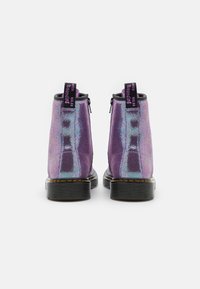 Botas de tobillo moradas con una superficie texturizada, acentos plateados y cremalleras traseras. Presenta una suela negra gruesa y lengüetas en bucle para facilitar su uso.