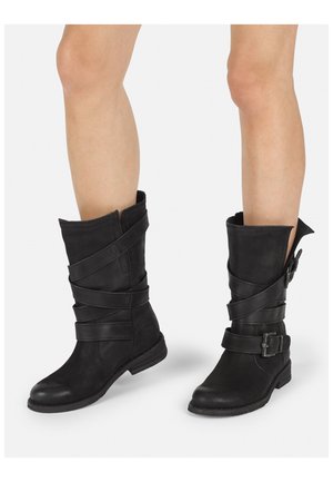 Botas de tobillo de cuero negro con un diseño arrugado, tiras entrelazadas y un detalle de hebilla lateral; tacón bajo y punta redonda.