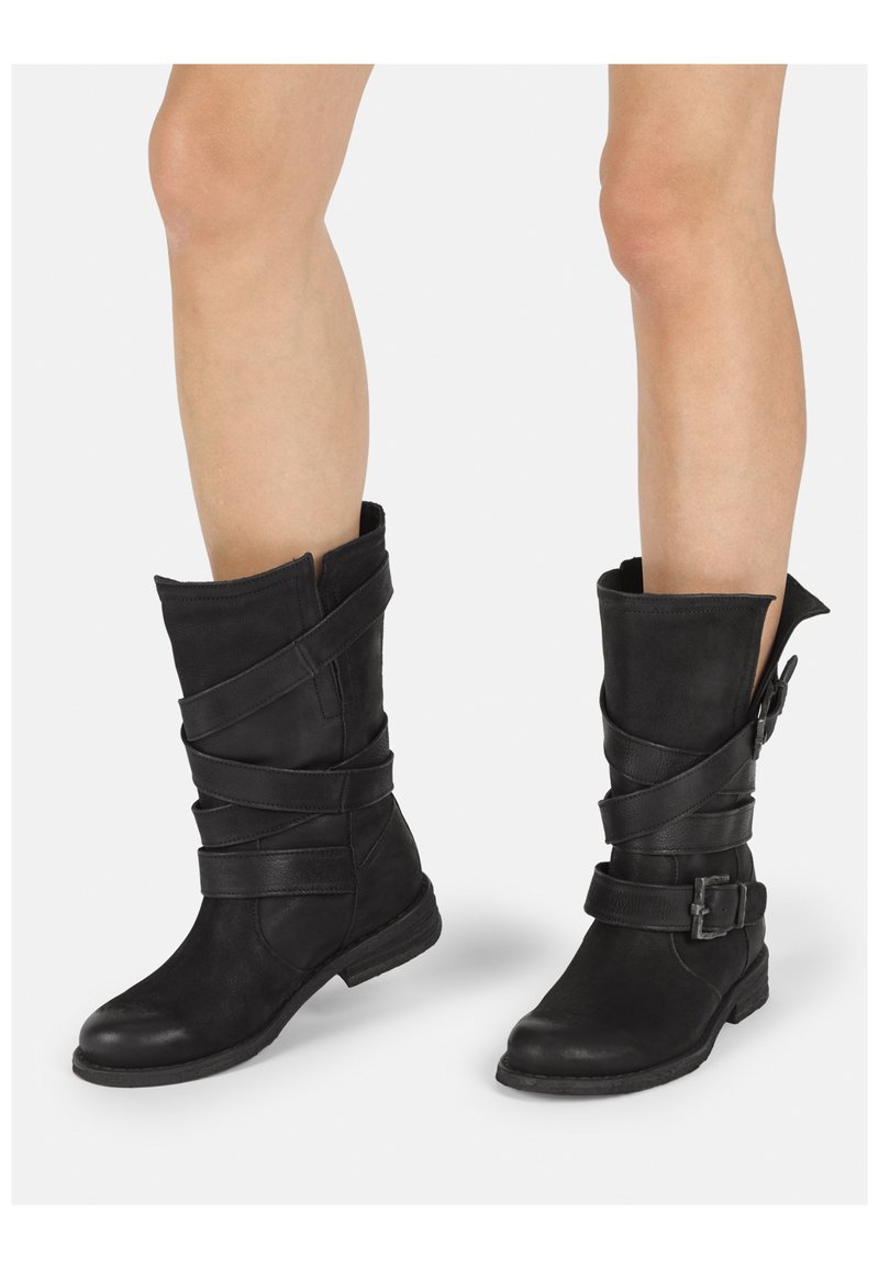 Botas de tobillo de cuero negro con un diseño arrugado, tiras entrelazadas y un detalle de hebilla lateral; tacón bajo y punta redonda.