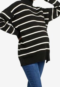 Svart randig tröja med vita horisontella linjer, design med hög hals, löst passform, ribbade ärmslut och nederkant. Tillverkad av mjukt stickat material.