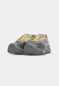 Gray and black trail running shoes with a breathable mesh upper, textured rubber outsole, and yellow laces. Lightweight and durable design.