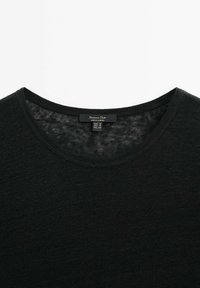 Zwarte crewneck T-shirt gemaakt van zachte stof, met een gladde textuur en een eenvoudig ontwerp. Etiket op de nek geeft merk en maat aan.
