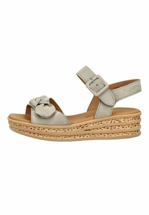 Beige kile sandal med tekstureret korksål, ankelrem med spænde og frontrem med dekorativ blomst detalje.