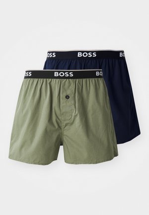 Dva páry boxerek: jedny olivově zelené a jedny tmavě modré. Oba mají černý pas s logem "BOSS" a detail knoflíku na přední straně.