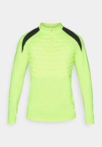 Langärmliges Sportoberteil in leuchtendem Neon-Gelb mit einem strukturierten hexagonalen Muster auf der Brust und schwarzen Akzenten an den Schultern.