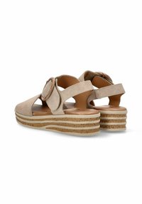 Sandalias de ante beige con hebilla redonda, correa trasera y suela de plataforma de corcho en capas. Diseño de punta abierta y ajuste ajustable.