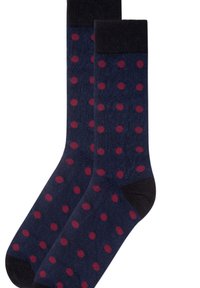 Ein Paar marineblauer Socken mit dunkelroten Punkten, schwarzer Zehen- und Bündchenpartie, flach auf einem weißen Hintergrund ausgelegt.