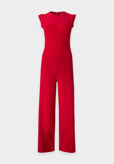 Combinaison rouge sans manches avec jambes larges et col rond, présentée sur un fond clair uni.