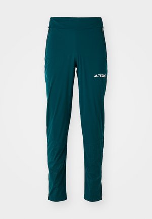 Teal wandelpantalon gemaakt van lichtgewicht, rekbaar materiaal. Voorzien van zippered pockets, taps toelopende benen en een gestructureerde afwerking aan de onderkant.