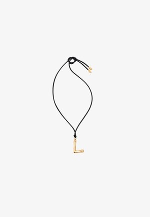 Pendente a forma di lettera "L" in tono oro su una collana con cordino nero, con una texture liscia e nodi scorrevoli regolabili per variare la lunghezza.