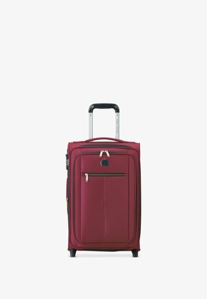 Valigia rossa con un esterno rigido, maniglia telescopica e tasca frontale con zip. Presenta accenti neri e quattro ruote per una facile mobilità.
