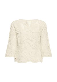 Blouse en dentelle au crochet crème avec bords festonnés et manches trois-quarts, vue de dos.