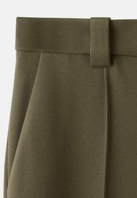 Pantalon taille haute vert olive avec une large passante de ceinture en tissu et des plis avant ajustés, présenté de la taille aux pieds.