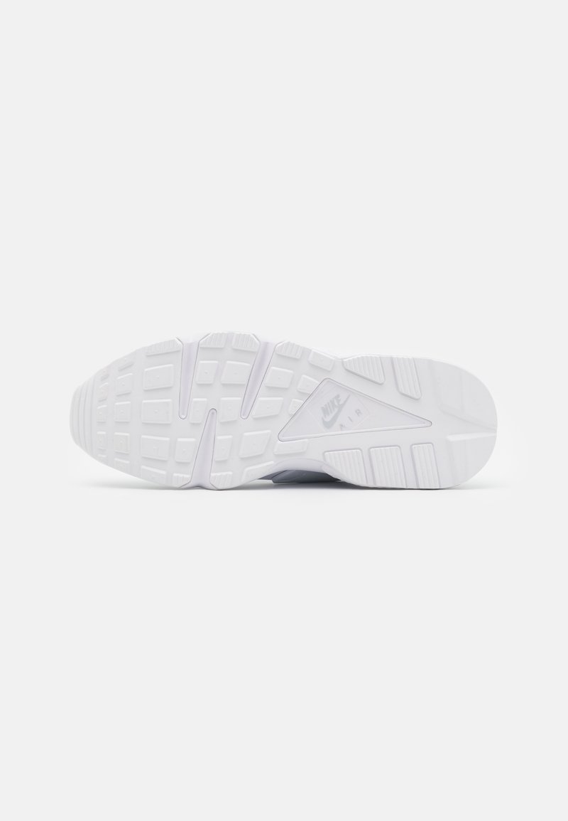 Weiße Sneaker-Sohle mit einer strukturierten Gumm Oberfläche, einem ausgeprägten Profilmuster und "Nike Air" Branding in der Zwischensohle.