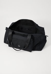 Schwarze Textil-Duffle-Tasche mit zwei Griffen, einem Reißverschluss an der Oberseite, einer Vordertasche mit Reißverschluss und Innenfächern. Verfügt über ein Logo-Tag auf der Vorderseite.
