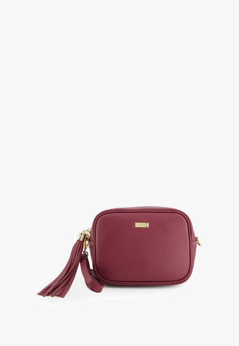 Maroon leather crossbody bag with a textured finish, gold hardware, and a decorative tassel. Rectangular shape with a zip closure.