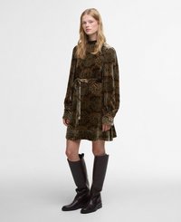 Robe en velours vert avec des motifs floraux ornés de doré et de marron, à manches longues, un col haut et une ceinture assortie ; associée à des bottes brunes hautes.
