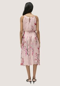 Blumenkleid im Midi-Längen in pinkem Stoff mit strukturierter Oberfläche, ausgestattet mit dünnen Trägern, einer taillierten Silhouette und einem Ausschnitt im Rücken.