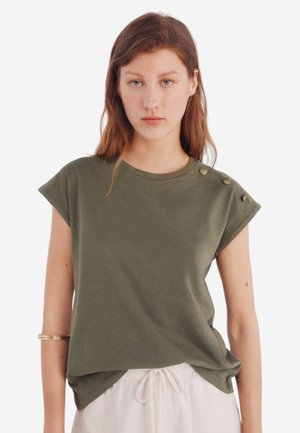 Oliven grøn kortærmet t-shirt med rund hals, dekoreret med knapper på skulderen og en afslappet pasform, lavet af blødt stof.