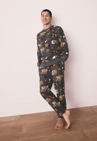 Ensemble de pyjama gris avec des motifs ludiques d'animaux et de citrouilles, fabriqué en tissu doux avec une coupe décontractée, poignets élastiques et taille élastiquée.