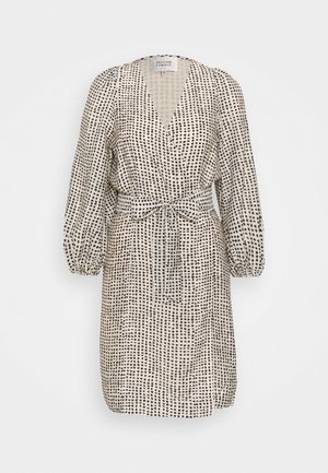Beiges Wickelkleid mit unregelmäßigem schwarzen Punktemuster, langen Puffärmeln, V-Ausschnitt und gebundenem Gürtel in der Taille.