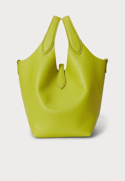 Torba od limetasto zelene kože s teksturiranim završetkom. Ima jedinstveni gornji otvor sa zakrivljenim ručkama i mekan, strukturiran oblik.